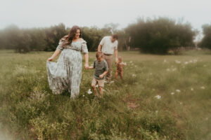 Mom and dad walking in a field with their boys